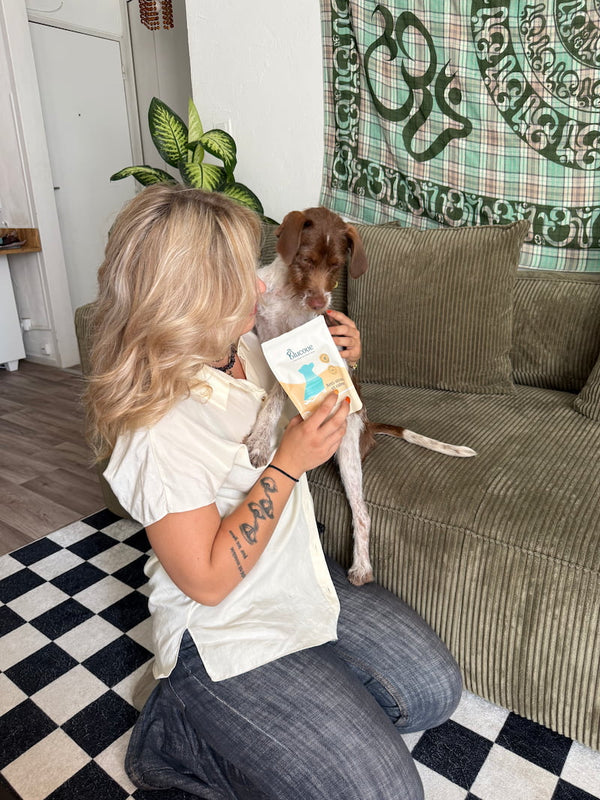 Cliente et son chien sur un canapé avec un complément anti-stress Blucove